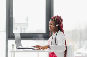 Telehealth, African American doctor in headset consulting with the patient over the phone call. Health care call center and telehealth online concept. photo