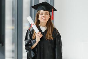 graduación estudiante en pie con diploma foto