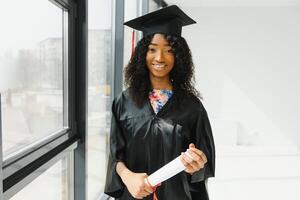 Alegre estudiante de posgrado afroamericano con diploma en la mano foto