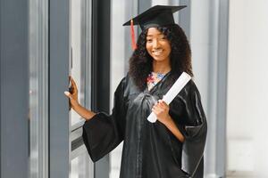 Alegre estudiante de posgrado afroamericano con diploma en la mano foto