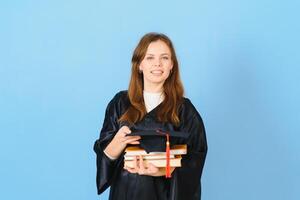 Beautiful woman wearing graduation cap and ceremony robe holding degree looking positive and happy standing and smiling with a confident smile. photo