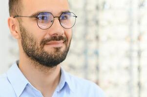 Glasses Shop. Man Trying On Eyeglasses In Optics Store photo