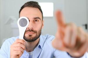 prueba de vista. hombre es comprobación su visión adentro en el clínica foto