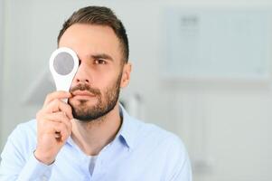 Test of sight. Man is checking his vision indoors in the clinic photo