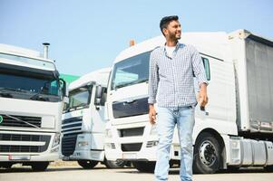 Young indian man standing by his truck. The concept of freight transportation. photo