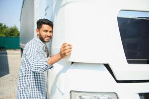 Young indian man standing in front of his truck. photo