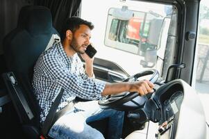 Indian truck driver tending a client on the phone photo