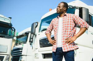 retrato africano masculino contento sonriente confidente positivo cerca camión. joven hombre tartán camisa propietario camión conductor en negocio largo transporte pulgares arriba satisfecho Servicio comercial conducción licencia formación foto