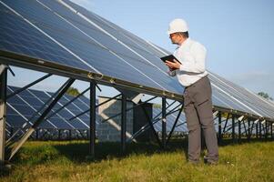 Solar power plant. Man standing near solar panels. Renewable energy photo