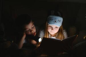 pequeño niños leyendo hora de acostarse historia a hogar foto