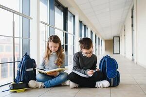 School kids with books together in corridor. Conception of education photo