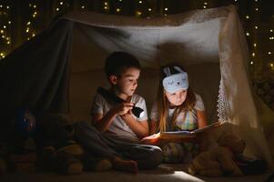 pequeño niños leyendo hora de acostarse historia a hogar foto