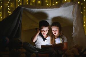 pequeño niños leyendo hora de acostarse historia a hogar foto