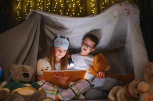 Little children reading bedtime story at home photo