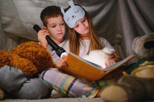 Little children reading bedtime story at home photo