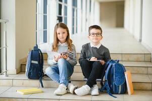 Happy school kids in corridor at school. Learning concept. photo