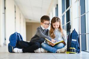 Portrait of smiling school kids in school corridor with books photo