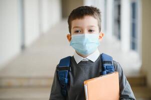 colegial con proteger máscara en rostro. coronavirus epidemia. un niño vistiendo un medicina mascarilla. coronavirus concepto. cara máscara para proteccion coronavirus brote. cara máscara en contra virus, enfermo, epidemia. foto