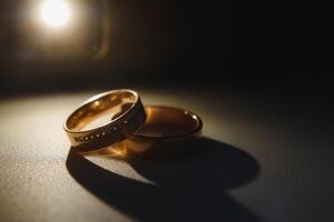 Elegant wedding rings for the bride and groom on a black background with highlights, macro, selective focus. photo