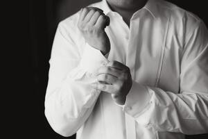 A man fastens buttons on his shirt photo