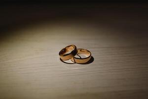 Elegant wedding rings for the bride and groom on a black background with highlights, macro, selective focus. photo