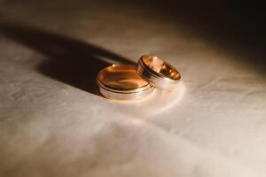 Elegant wedding rings for the bride and groom on a black background with highlights, macro, selective focus. photo