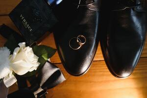 Elegant wedding rings for the bride and groom on a black background with highlights, macro, selective focus. photo