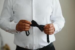 A man fastens buttons on his shirt photo