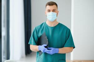 Portrait of male doctor wearing surgical mask is ready to help patients with coronavirus or covid virus. photo