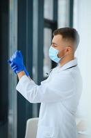 Portrait of male doctor wearing surgical mask is ready to help patients with coronavirus or covid virus. photo