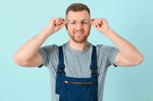 Handsome young craftsman over isolated blue background photo