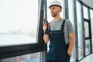 handsome young man installing bay window in new house construction site photo