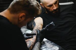 Professional tattoo artist working in his tattoo studio. photo