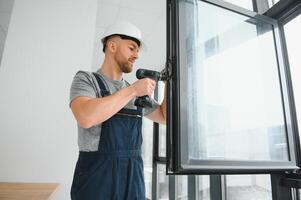 service man installing window with screwdriver photo