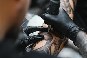 tattooist with his machine tattooing on the arm with the design drawn, concept of art and design photo