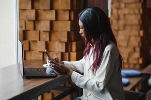 contento africano americano mujer trabajador utilizando ordenador portátil trabajo estudiar a computadora en desván oficina o cafetería, sonriente mezclado carrera hembra estudiante persona de libre dedicación utilizando ordenador personal aplicación Fechado comunicado en línea acecho seminario web foto