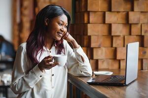 Focused young african american businesswoman or student looking at laptop, serious black woman working or studying with computer doing research or preparing for exam online photo