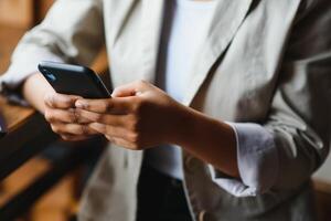 Crop close up of African American woman hold cellphone text message online on gadget. Ethnic biracial female use smartphone browse surf wireless internet on device. Technology, communication concept. photo