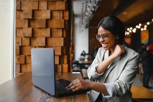 Very happy African-Americam woman reading exciting news online photo