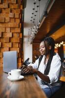 suerte día. emocional negro mujer mirando a computadora portátil, apretando puños y gritando, trabajando a cafetería, Copiar espacio foto