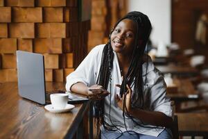 suerte día. emocional negro mujer mirando a computadora portátil, apretando puños y gritando, trabajando a cafetería, Copiar espacio foto