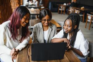 Happy African American Women, friends sitting together at the restaurant. photo