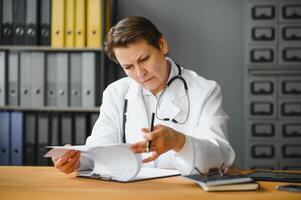 Portrait of middle age female doctor is wearing a white doctor's coat with a stethoscope around her neck. photo