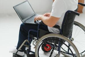 moderno joven discapacitado hombre en silla de ruedas teniendo llamada foto