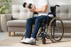 Man Disabled. Sports for Disabled. Male in Wheelchair with Dumbbells in Hands. Man with Dumbbells in Hands. Father Disabled Do Spotting. Sport at Apartment. Health Concept. Healthy Lifestyle photo