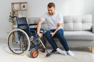 Disabled young black guy trying sit down. photo