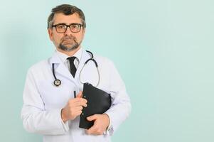 sonriente médico mayor médico con un estetoscopio. en un azul antecedentes. el concepto de de la humanidad victoria terminado enfermedad foto