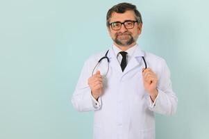 sonriente médico mayor médico con un estetoscopio. en un azul antecedentes. el concepto de de la humanidad victoria terminado enfermedad foto