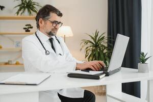 Portrait of senior doctor sitting in medical office. photo