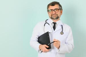 sonriente médico mayor médico con un estetoscopio. en un azul antecedentes. el concepto de de la humanidad victoria terminado enfermedad foto